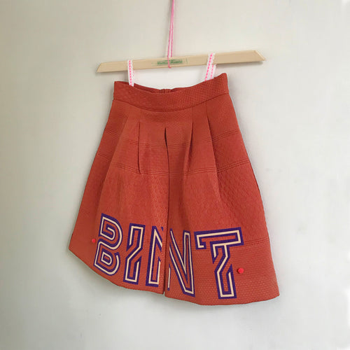 Bint pleated A-line skirt with pom-poms